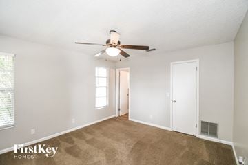 Jacksonville house for rent - a living room with carpet and a ceiling fan