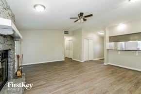 Greenwood house for rent - A spacious room with a fireplace and a ceiling fan.