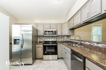Greenwood house for rent - A kitchen with a stainless steel refrigerator and a granite countertop.