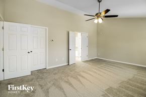 Greensboro house for rent - A spacious room with a ceiling fan and carpeted floor.