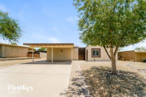 Tucson house for rent - a house with a driveway and a tree in front of it