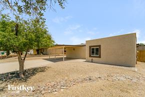Tucson house for rent - a house with a dirt yard and a tree in front of it