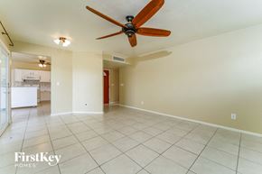 Tucson house for rent - an empty living room with a ceiling fan and a tiled floor