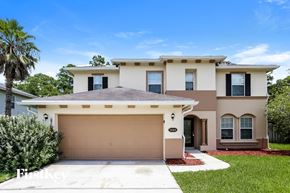 Yulee house for rent - a beige house with a garage door and a palm tree
