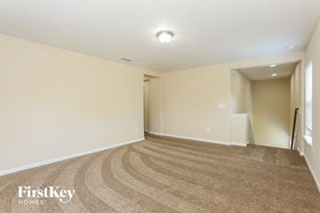 Yulee house for rent - a spacious living room with carpet and a door to a hallway