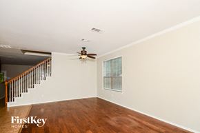 Melissa house for rent - A room with a wooden floor and a ceiling fan.