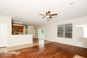 Melissa house for rent - A spacious living room with a wood floor and a ceiling fan.