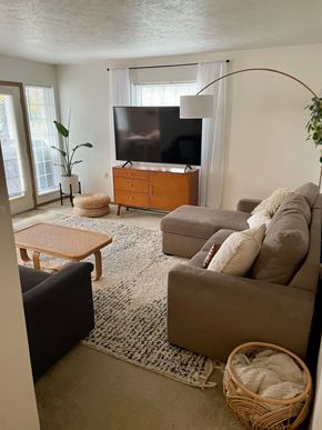 Spokane apartment for rent - A living room with a couch, a coffee table, a TV, and a plant.