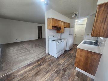 Spokane apartment for rent - an empty kitchen with white appliances and wooden floors