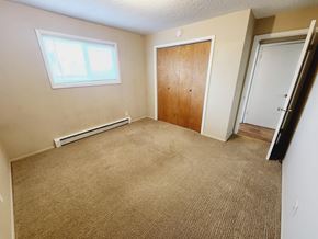 Spokane apartment for rent - an empty room with a carpeted floor and a door