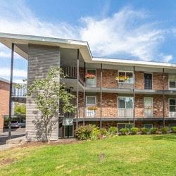 Spokane apartment for rent - a large brick apartment building with a green lawn