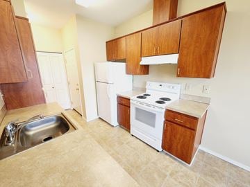 Medical Lake apartment for rent - A kitchen with white appliances and wooden cabinets.
