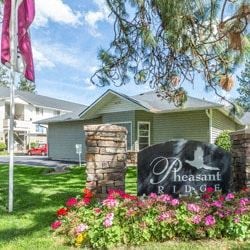 Spokane Valley apartment for rent - a house with a sign and flowers in front of it