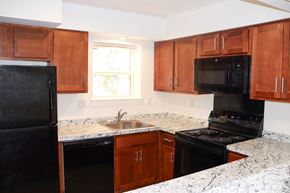 Sicklerville apartment for rent - an empty kitchen with granite counter tops and black appliances