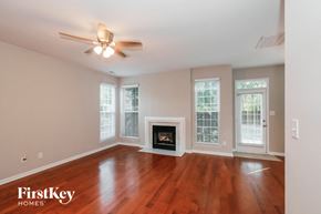 Monroe house for rent - A room with a fireplace and a ceiling fan.