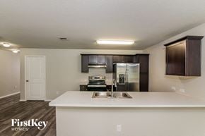 Converse house for rent - a kitchen with a sink and a stainless steel refrigerator