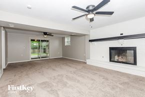 Dayton house for rent - an empty living room with a fireplace and a ceiling fan