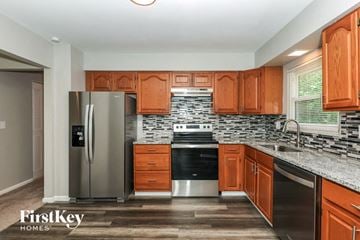 Dayton house for rent - a kitchen with wooden cabinets and a stainless steel refrigerator