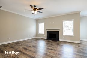 Gainesville house for rent - A spacious living room with a fireplace and a ceiling fan.