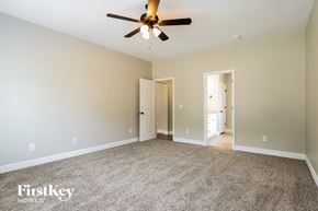 Gainesville house for rent - A spacious room with a ceiling fan and two doors.