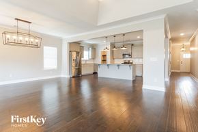 Helena house for rent - A spacious living room with wooden floors and a large mirror on the wall.