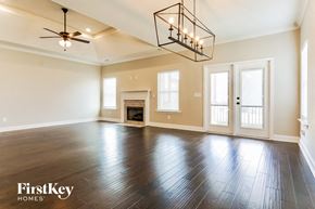 Helena house for rent - A spacious room with a fireplace and a chandelier.