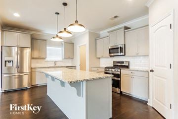Helena house for rent - A kitchen with a stove top oven and a microwave.