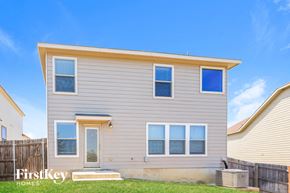 San Antonio house for rent - A two-story house with a beige exterior and a brown fence.