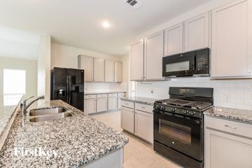 Texas City house for rent - a white kitchen with granite counter tops and stainless steel appliances