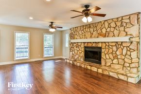Hiram house for rent - a living room with a stone fireplace and a wooden floor