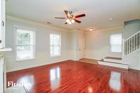 Dublin house for rent - A spacious room with a wooden floor and a ceiling fan.