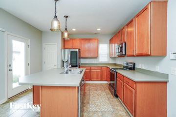 Dublin house for rent - A kitchen with orange cabinets and a white island.