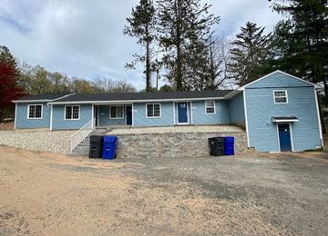 Bolton apartment for rent - a blue house with blue trash cans in front of it