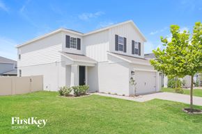Riverview house for rent - A white two-story house with a tree in front.
