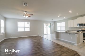 Riverview house for rent - A spacious kitchen and living room with wooden floors and white walls.