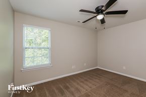 Charlotte house for rent - a bedroom with a ceiling fan and a window