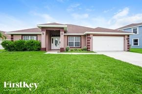 Lehigh Acres house for rent - A house with a brown roof and a white garage door is for sale.