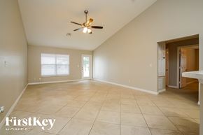 Lehigh Acres house for rent - A spacious room with a ceiling fan and tiled flooring.