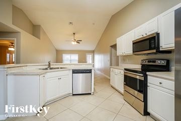 Lehigh Acres house for rent - A kitchen with white cabinets and stainless steel appliances.