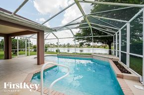 Lehigh Acres house for rent - A swimming pool under a glass roof with the words "FirstKey Homes" on the bottom.