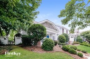 Charlotte house for rent - A white house with a blue door and a sign that says "FirstKey Homes".