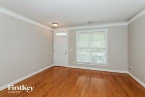 Charlotte house for rent - A room with wooden floors and a window with blinds.