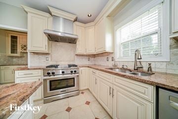 Atlanta house for rent - a large kitchen with white cabinets and stainless steel appliances