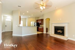 Yulee house for rent - an empty living room with a fireplace and a ceiling fan
