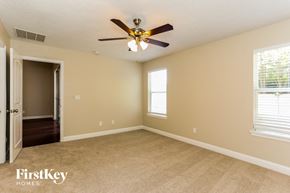 Yulee house for rent - a bedroom with a ceiling fan and a door to a hallway