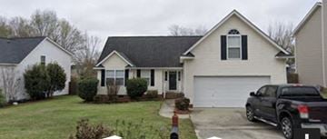 Lexington house for rent - A white house with a black roof and a garage door.