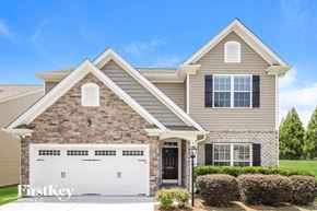 Lewisville house for rent - a tan brick house with a white garage door