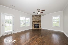 Lewisville house for rent - an empty living room with a fireplace and a ceiling fan