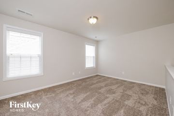 Lewisville house for rent - a spacious living room with carpet and two windows