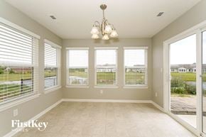Indianapolis house for rent - an empty living room with large windows and a chandelier